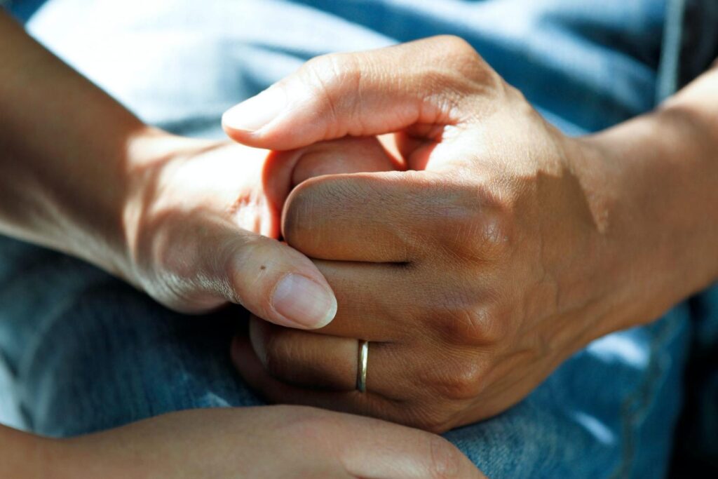 nurse holding resident's hand in comfort