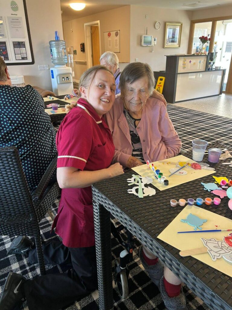 nurse with arm round resident