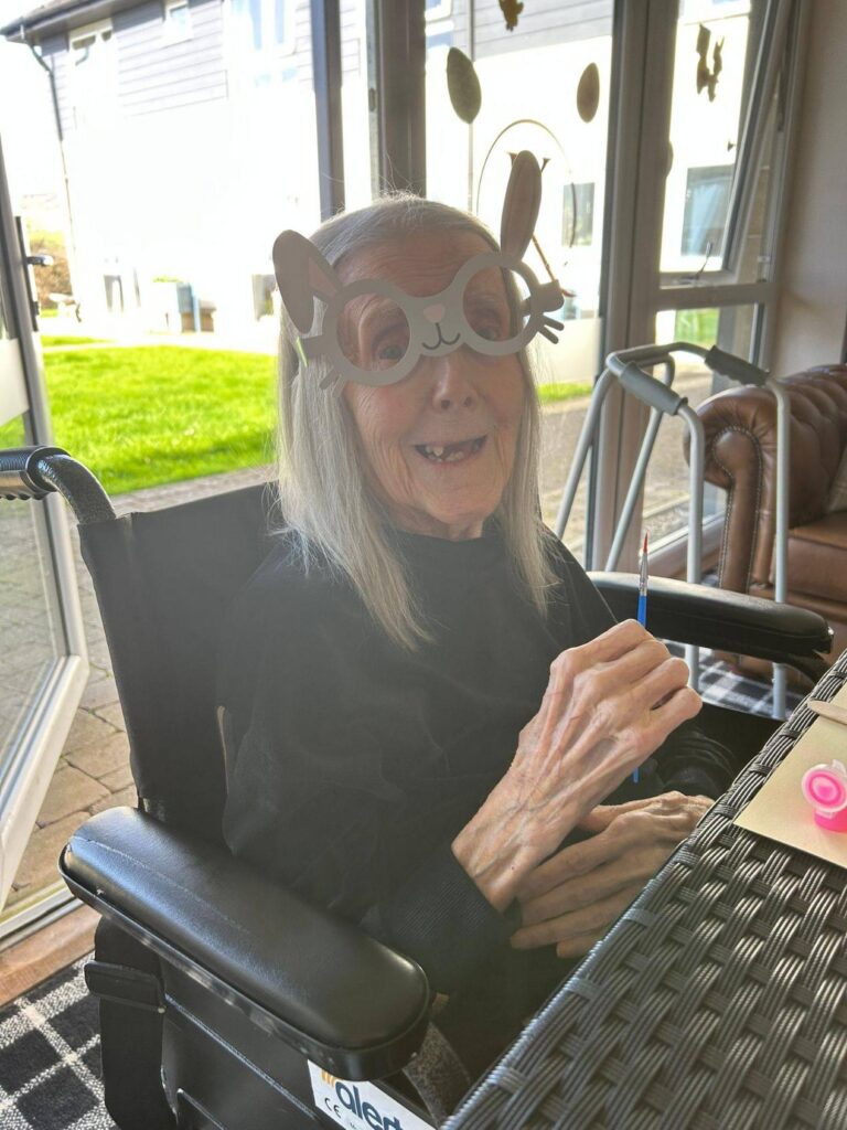 elderly woman smiling in easter glasses