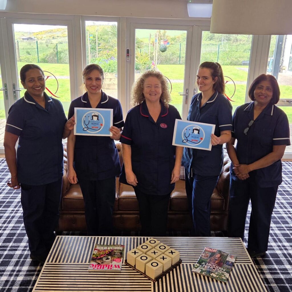 group of nurses in blue uniforms smiling together