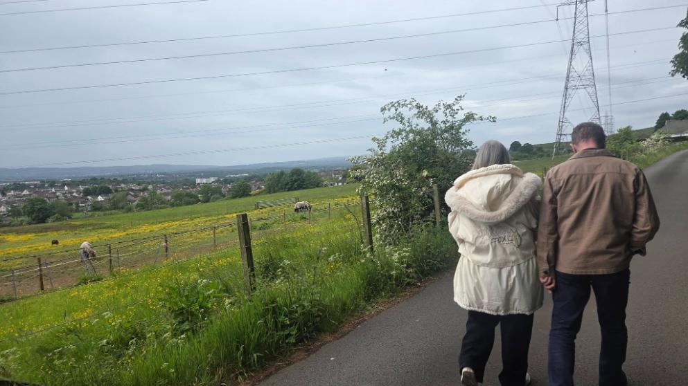 older adults walking outside by a field