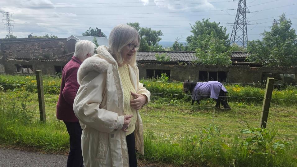 older adults standing by a pony
