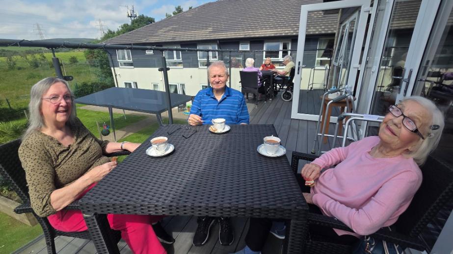 residents sat at a table outdoors