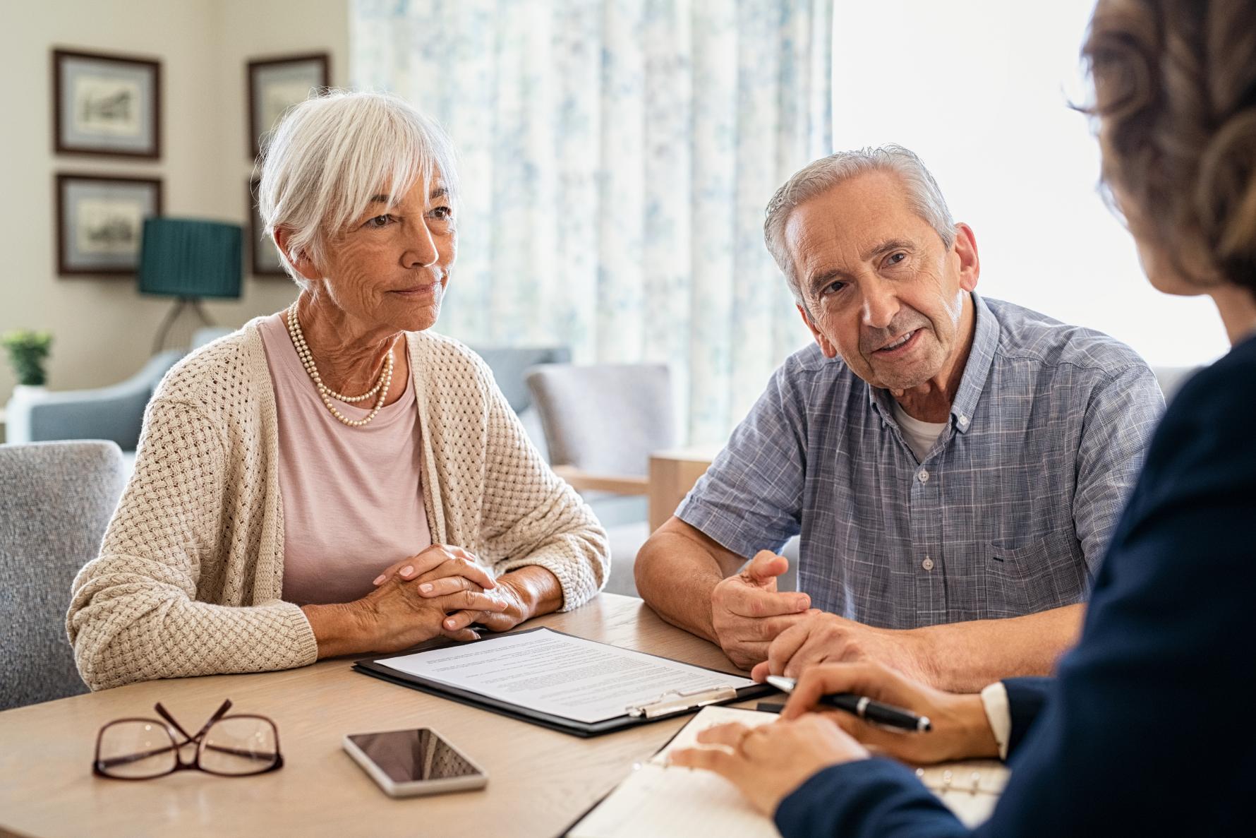 an elderly couple discussing care options with staff