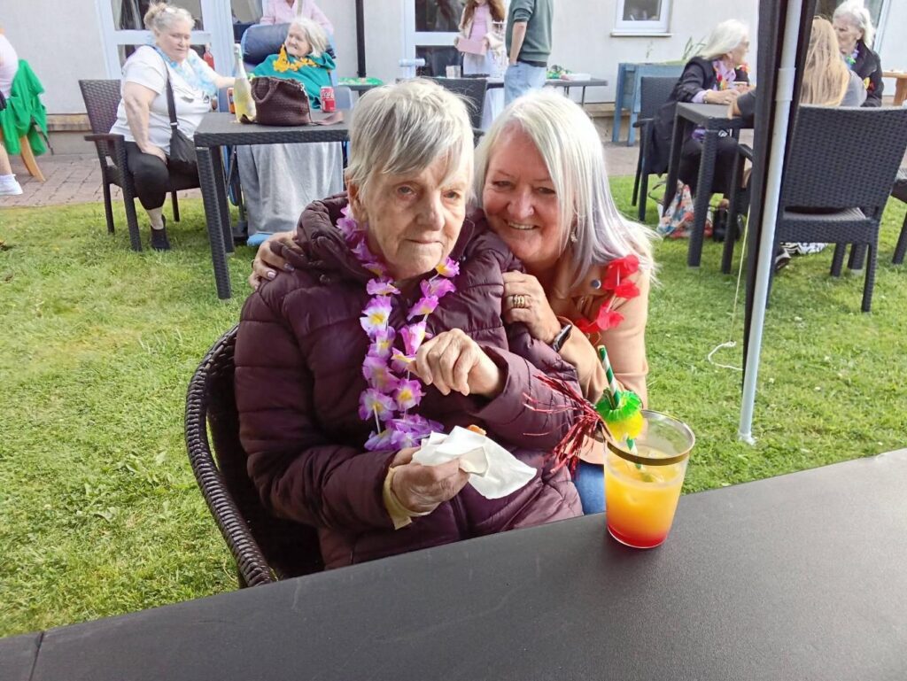 mother and daughter smiling at care home summer fete