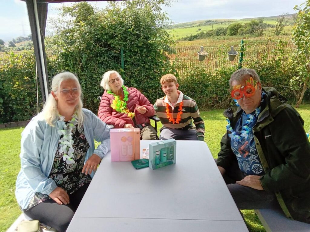 family smiling outdoors at care home summer fete